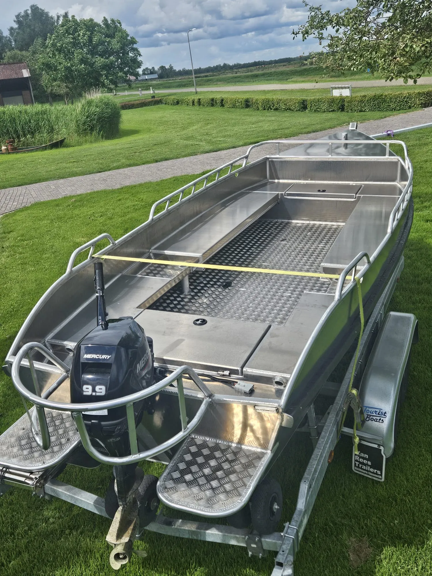 Opgeleverde aluminium platbodem met Mercury-motor op trailer
