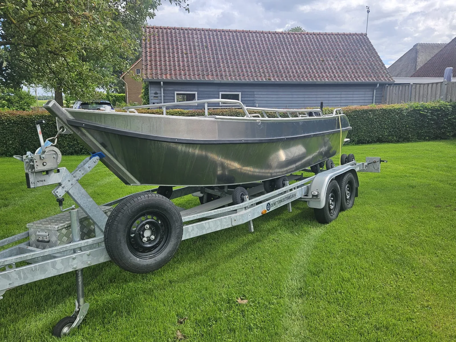 Aluminium punter van De Wetering Botenbouw op een trailer bij een boerderij